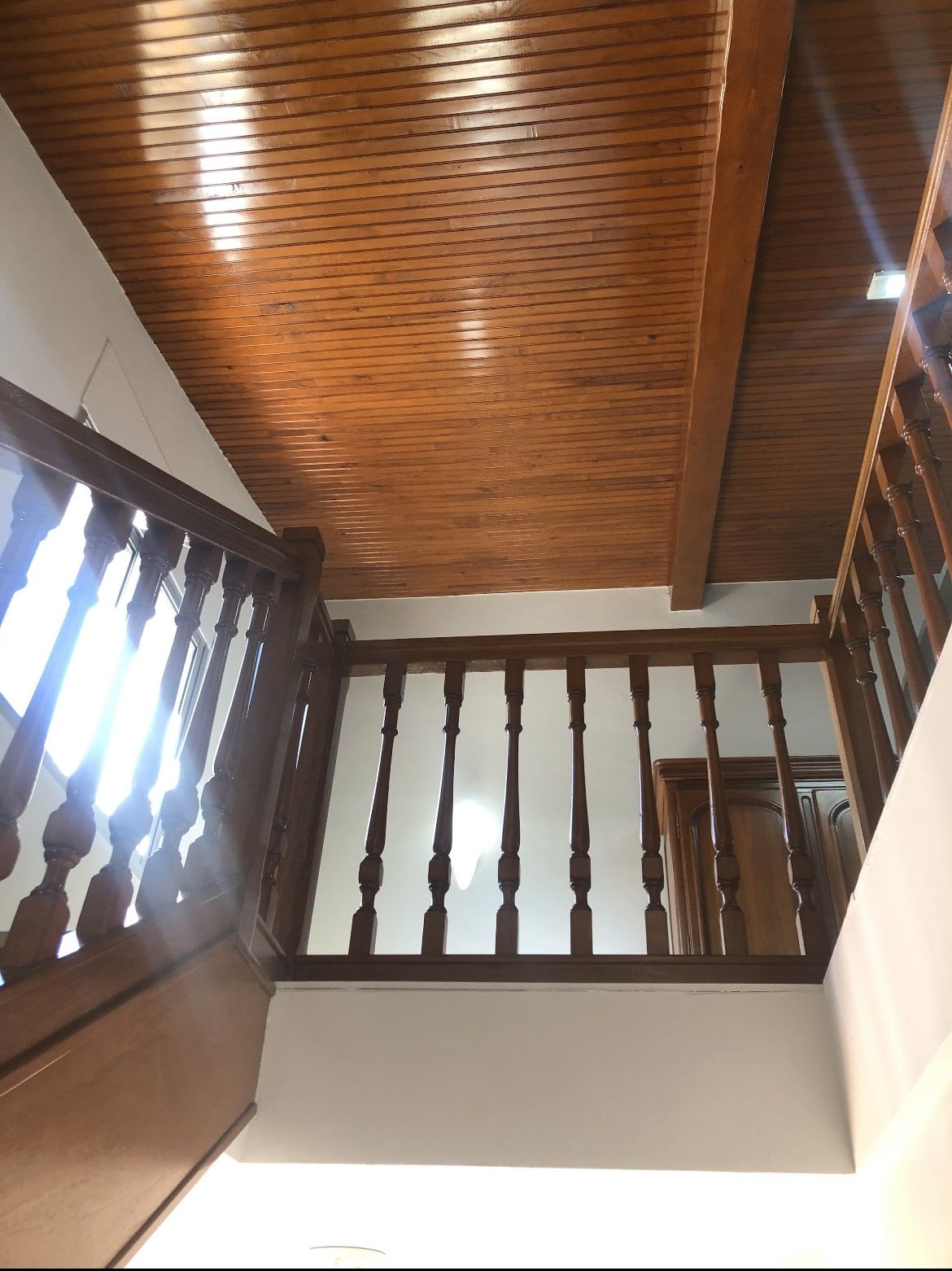 Plafond en lambris et garde-corps à balustres en bois teinté